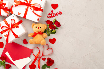 Valentine's Day composition with gifts and red roses on concrete background, top view