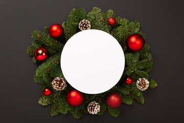 Festive Christmas tree branches with mock up black on color background, top view