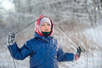 Portrait of a charming girl holding a sled rope in snowy winter