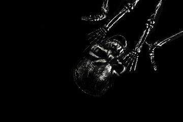 Obraz premium Grungy Silver Skeleton Lying on a Pure Black Background in Low Key Lighting for Halloween Horror, Death and Mystery Concept