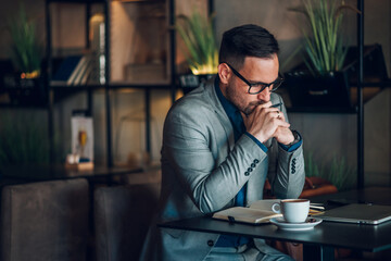 Businessman working remotely from cafe is thinking about his next move