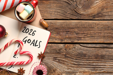 Notebook with 2026 goals and Christmas decor on wooden background