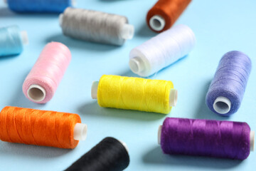 Set of colorful thread spools on blue background