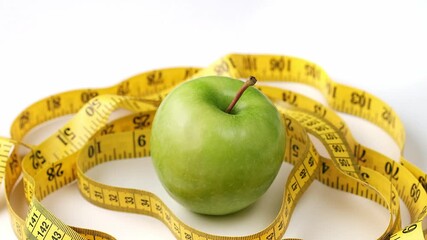 green apple with measuring tape - closeup - Powered by Adobe