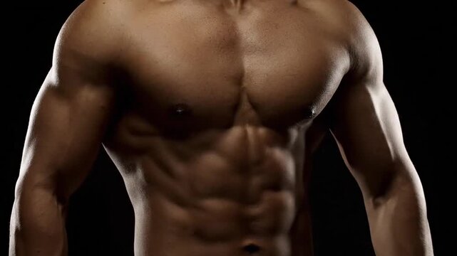 Detailed Close Up of a Muscular Torso on Black Background Showing Defined Abdominal Muscles and Chest With Dramatic Lighting