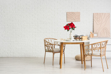 Interior of room with Christmas plant poinsettia on dining table and paintings
