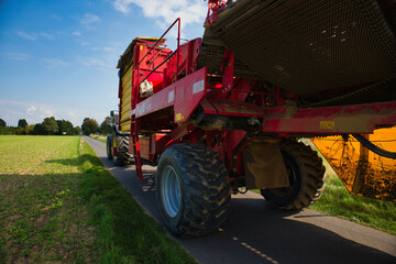 Obraz premium Modern agricultural machinery working on rural road during sunny day in the countryside