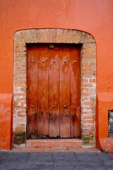 Weathered Wooden Door in Orange Wall with Brick Arch (Mexico City, Mexico)