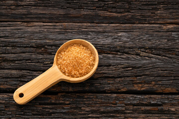 Organic brown sugar in a wooden spoon - Saccharum officinarum