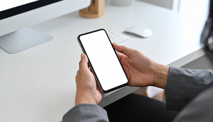 Woman hands holding a blank screen a smartphone on work desk.