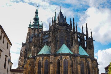 Beautiful aerial and detailed view of St. Vitus Cathedral in Prague Castle, Czech Republic, showcasing Gothic architecture, gargoyles, stained glass, and the historic city skyline.