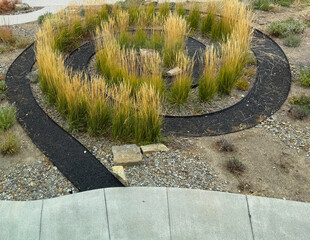 Put your mind at rest. See labyrinth spiral path formed from natural grass vegetation in the outdoors. A continuous circle ends at a central rock. Used in psychology  as an aid for mental thought.