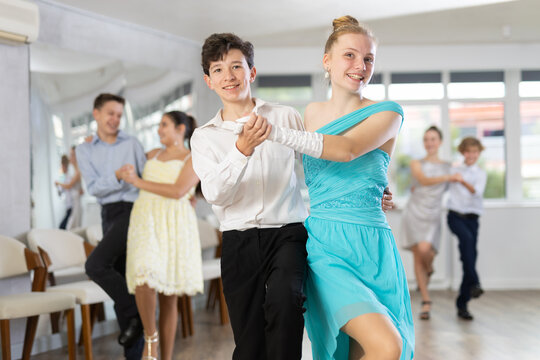 During rehearsal of reporting concert, adolescence boy and girl participants of dance workshop perform lindy hop under guidance of female mentor