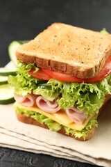 Tasty sandwich with ham, cheese and vegetables on grey table, closeup