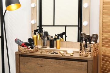 Different hair styling tools on wooden vanity in salon