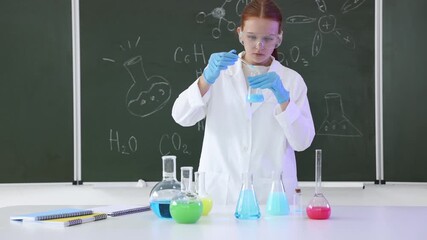 Back to school. Girl doing chemical research at desk against chalkboard with formulas indoors - Powered by Adobe
