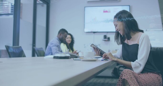 Using tablet and stylus, woman in business casual attire working in conference room, copy space
