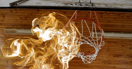 Swirling flame effect engulfing basketball hoop rim and net inside gymnasium, with wooden ceiling