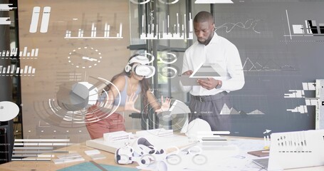 Asian Indian woman wearing VR headset manipulating virtual data in design studio, with VR headsets