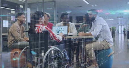 Collaborating six colleagues discussing data around table in office, with laptop and wheelchair