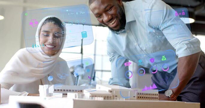 Leaning architect and engineer studying scale model on table in office, with AR data overlays