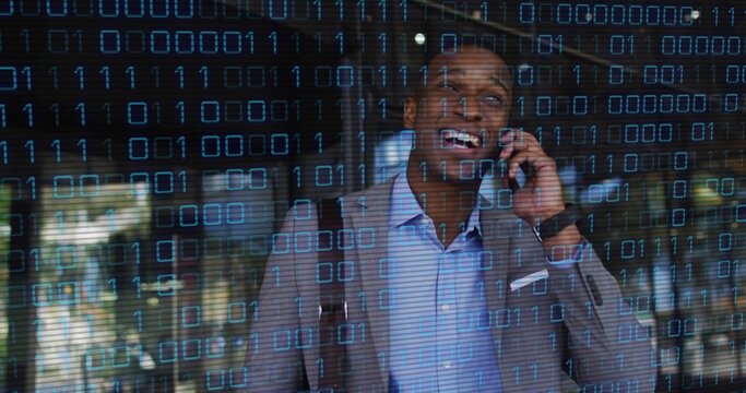 Talking businessman holding smartphone to ear at lobby, with binary code overlay on glass wall