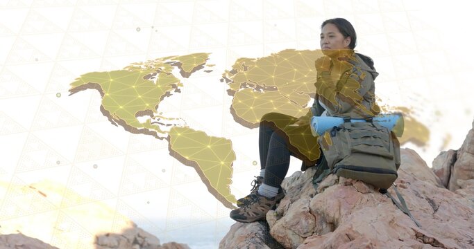 Hiker sitting on outcrop at sunset, with digital map overlay showing network nodes, copy space
