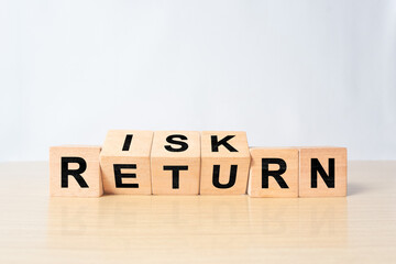 Flipping of wooden cubes block which print screen risk and return wording. Investment concept about balance between risk and return