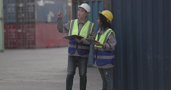 Industrial container workers discussing eco-friendly logistics strategies. Reducing fuel consumption, lowering carbon footprints, and implementing zero-emission practices in supply chain operations.
