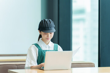 パソコンで事務仕事をする飲食店スタッフ