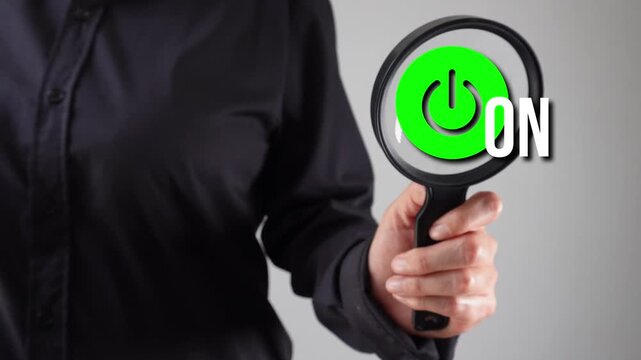 A person with a magnifying glass analyzing the animation of a power sign with the word "On"