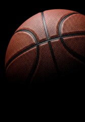 Detailed close-up of a classic brown leather basketball on a black background