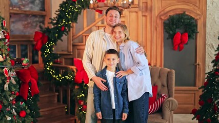 Joyful family celebrates Christmas, creating happy holiday memories. Parents and child smile, enjoying festive decorations and cozy atmosphere. Love and togetherness radiate.