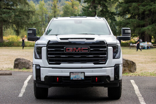 Skamania, WA, USA - Sep 27, 2025 - White GMC Sierra HD AT4 heavy duty pickup truck parked in public parking lot of a forest park, showing modern design and power vehicle built for towing and work use