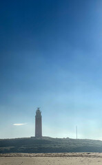 A stunning scenic view showcasing a lighthouse beautifully set against a serene and calming blue sky