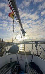 A breathtaking view from the deck of a sailboat, capturing a sunset along with beautiful, expansive skies