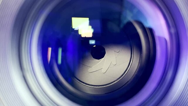 Close-up macro of a camera lens aperture blades opening and closing, showing light reflections and optical elements in motion, concept of photography, focus, and precision