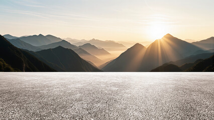 Under a cloudy sky, the wide asphalt road and the distant mountains set against the backdrop