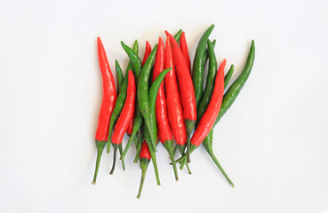 Red and green chili peppers against white background, preparation process of chilli for cooking. Top view.