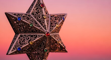 Ornate metallic star ornament with colorful gemstones against a soft sunset sky
