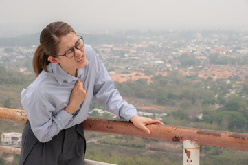 Asian woman having respiratory allergy and chest pain becaused of by Bad air pollution (PM2.5) covered Chiang Rai province, Thailand. PM2.5 levels meaning the air quality posed a health hazard.