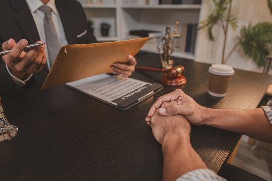 A professional lawyer discussing legal matters with a client in an office, providing legal advice and document review services, symbolizing justice, trust, and professional consultation.