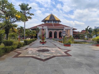 Fototapeta premium Beautiful mosque with garden and blue sky on a bright sunny day in Indonesia.