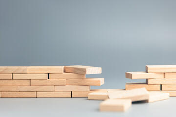 Wooden blocks forming a wall or bridge with a missing section symbolizing gap analysis, teamwork issues, or lack of connection in business and communication