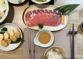 Top View of Set of Shabu including Sliced Beef, Rice, Sauce, Tofu and Vegetable