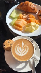 A buffet table with a variety of dishes, including fruits, vegetables, salads, and desserts. The table is decorated with greenery and flowers, creating an inviting atmosphere.