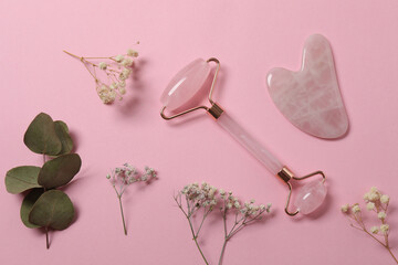 Facial massage tool. Quartz jade roller, on a pink background.
