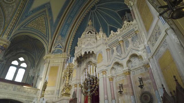 Pan-down view of Szeged Synagogue&rsquo;s altar, highlighting ornate design and cultural significance with Israeli and Hungarian flags displayed