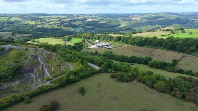 Scenic drone footage of Crich stone quarry with exposed rock faces and surrounding countryside in the Derbyshire Dales, United Kingdom