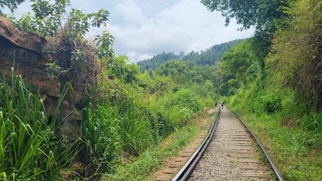 Rail tracks of the iconic Badulla&ndash;Colombo railway near Ella, Sri Lanka, weaving through lush tropical jungle in the misty highlands. Scenic view of Sri Lanka&rsquo;s legendary train route